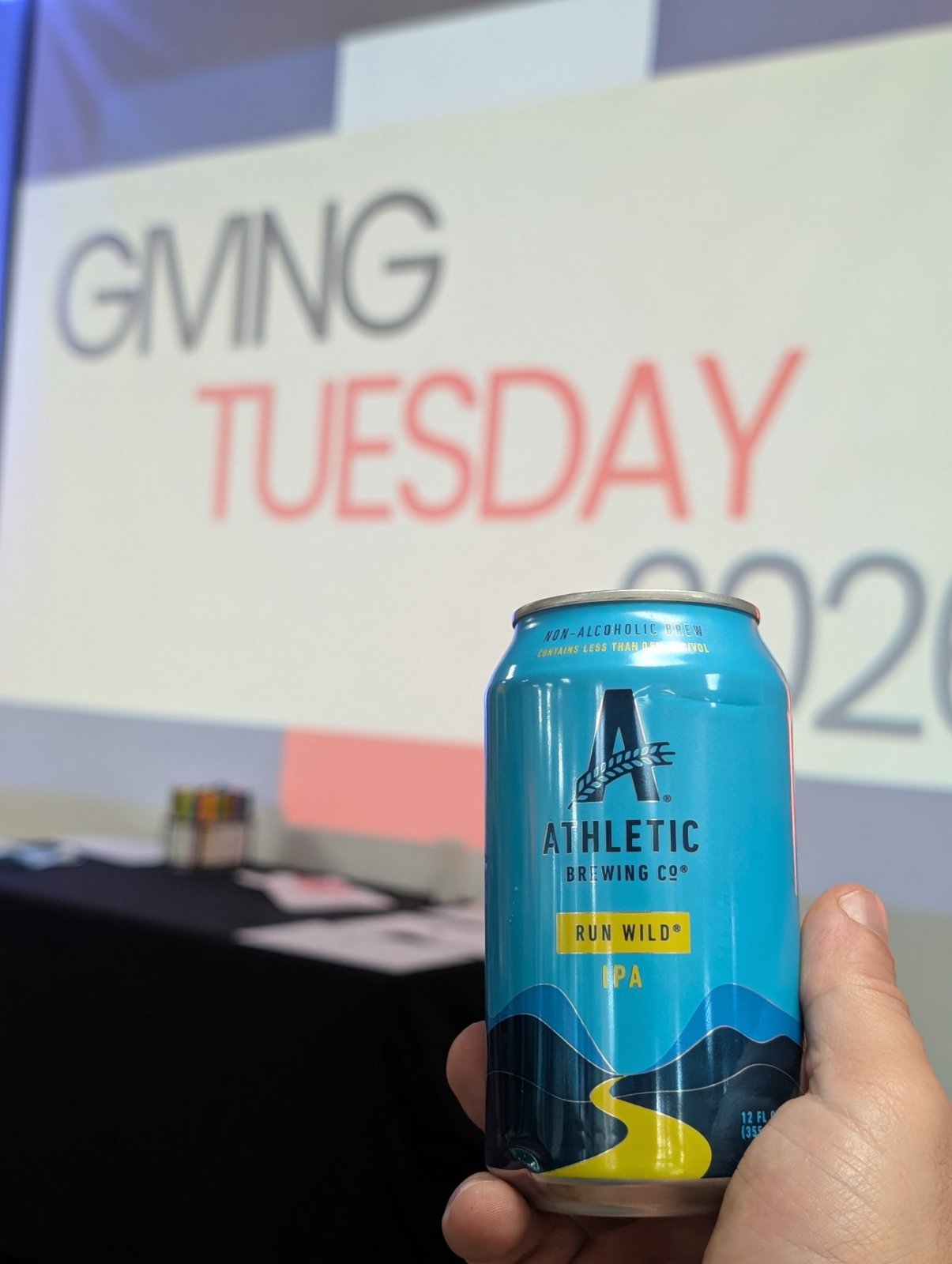 A non-alcoholic brew held up in front of the GivingTuesday screen