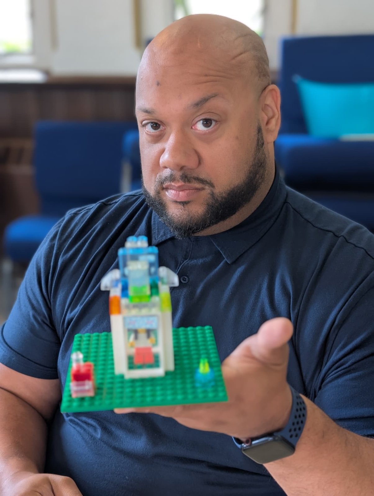 Ben Williams holding up a small brick-built model